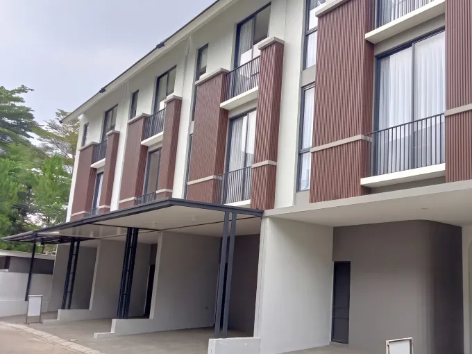 Modern apartment building with brown vertical siding, large windows, and glass balconies.