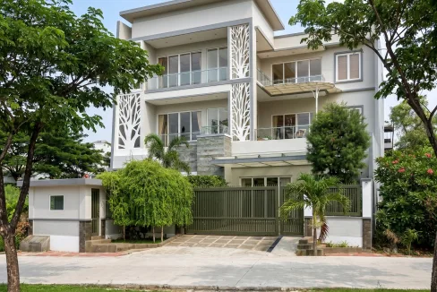Modern White Apartment Building with Glass Balconies Gray Accents and Lush Green Trees in Front  Rooma21com